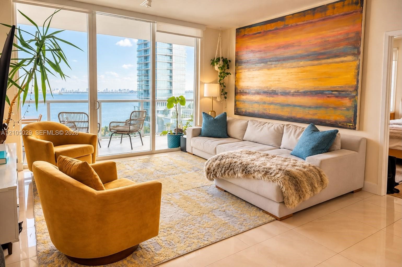 Floor-to-ceiling glass sliding doors, private balcony, neutral large-format tile flooring, and track lighting