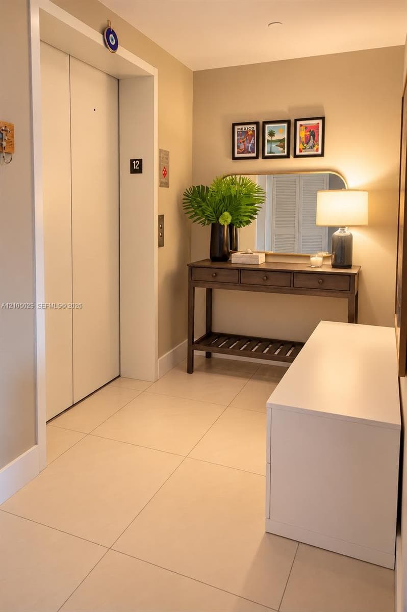 Elevator access featuring neutral-toned ceramic tile flooring and light-colored walls