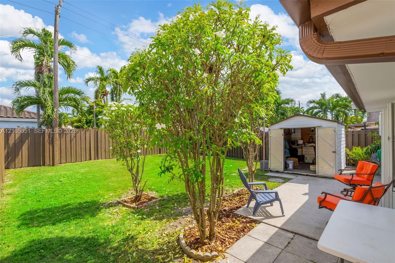 Backyard featuring a concrete patio, perimeter privacy fencing, and a detached storage structure