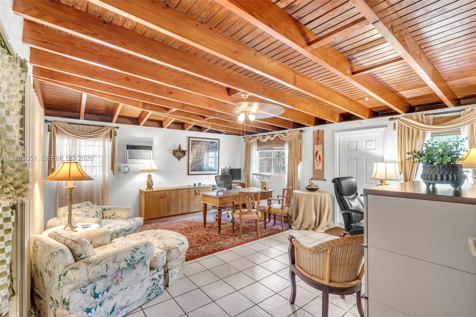 Room featuring exposed natural wood-toned ceiling beams