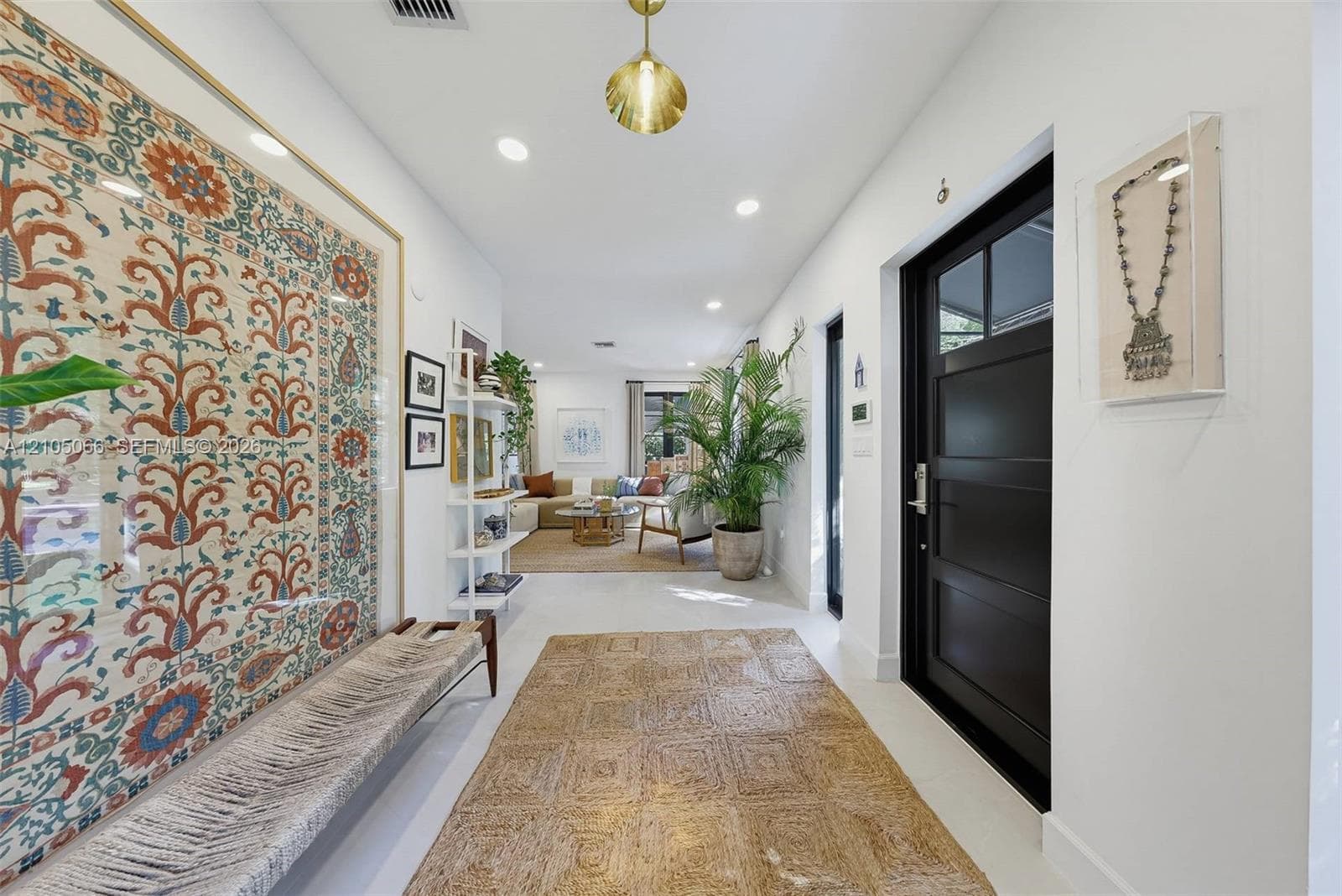 Entryway featuring a black multi-panel door with glass inserts, recessed lighting, and a pendant fixture with a metallic finish