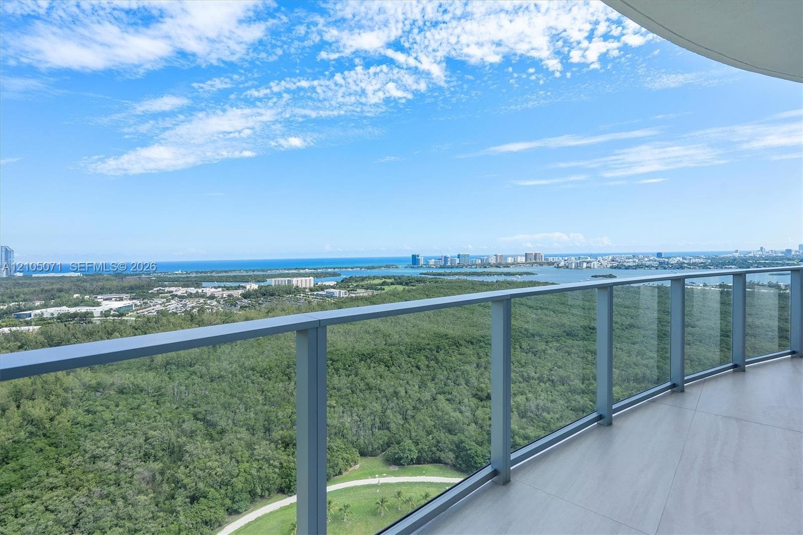 Private balcony featuring tile flooring and a metal-framed glass railing