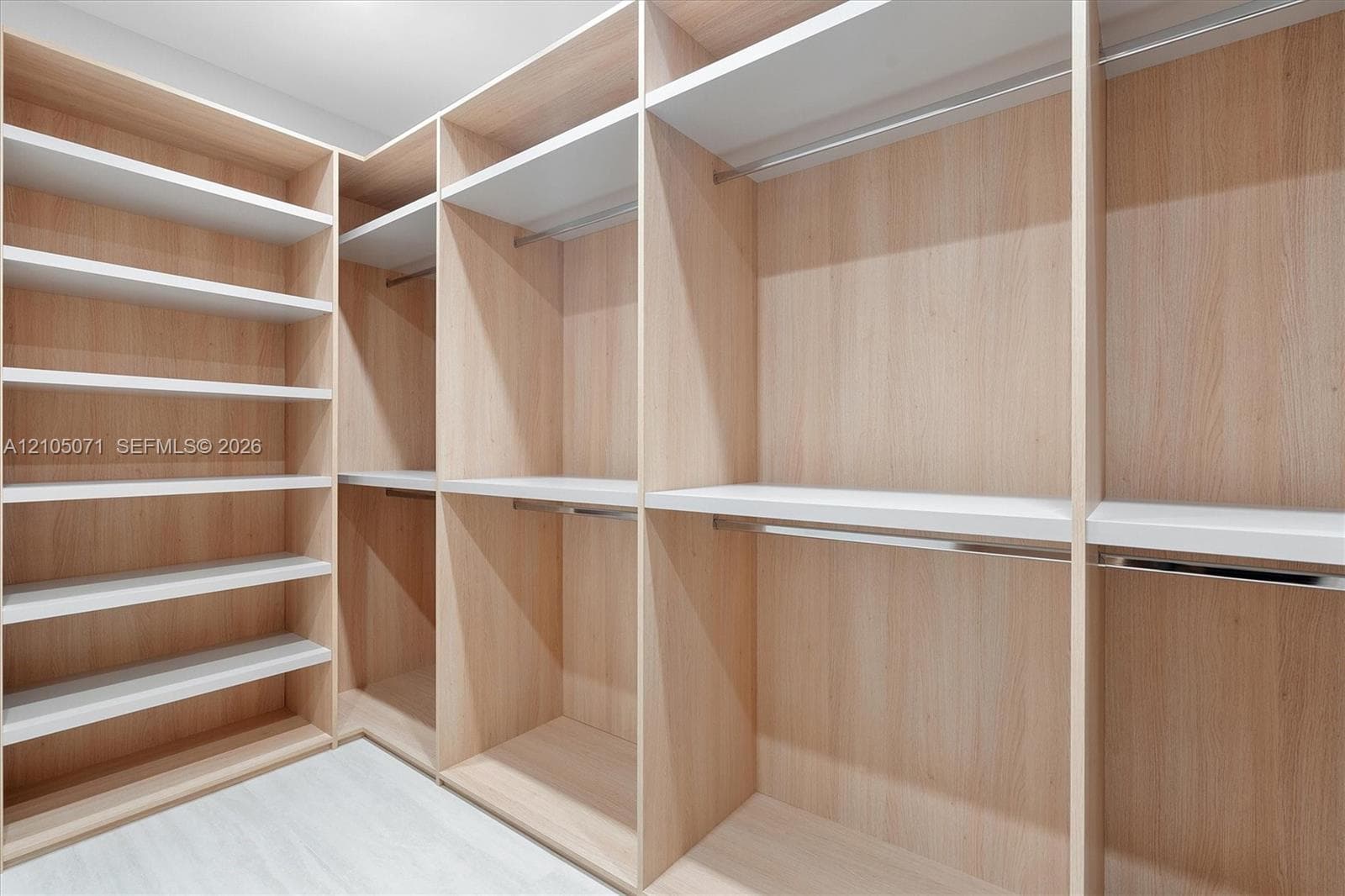 Custom-built wood-finish shelving with integrated hanging rods and white shelving surfaces
