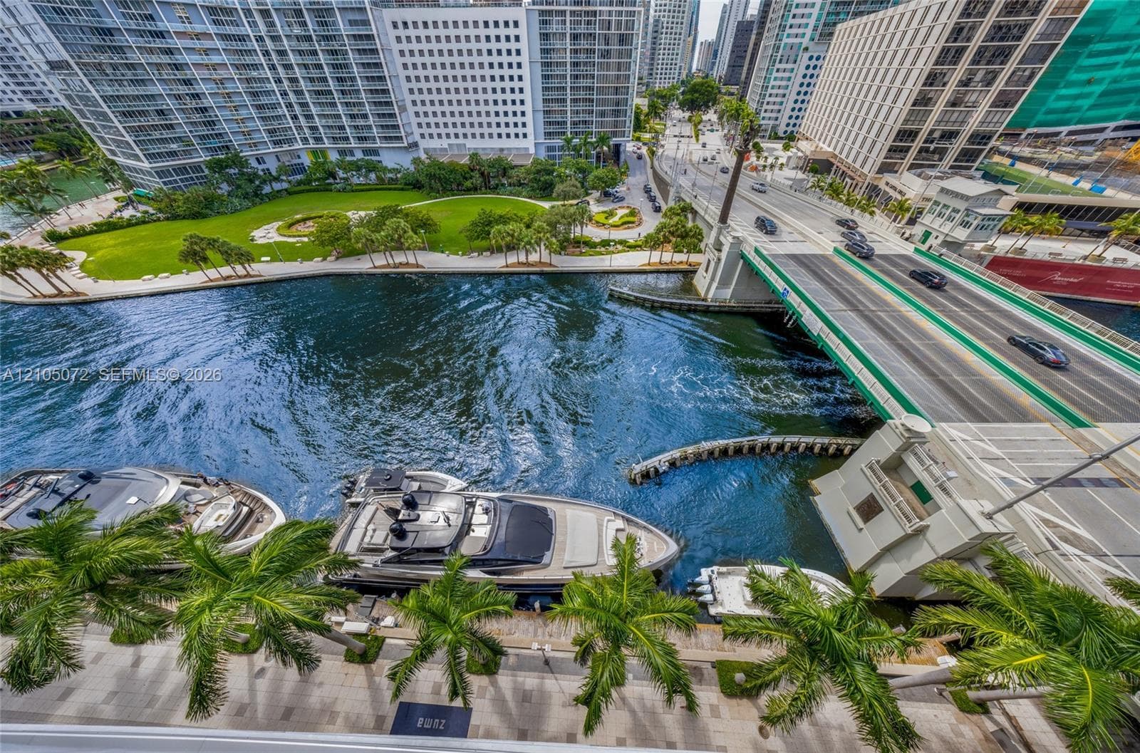 Miami River waterfront beside the Brickell Avenue Bridge, with boats moored below.