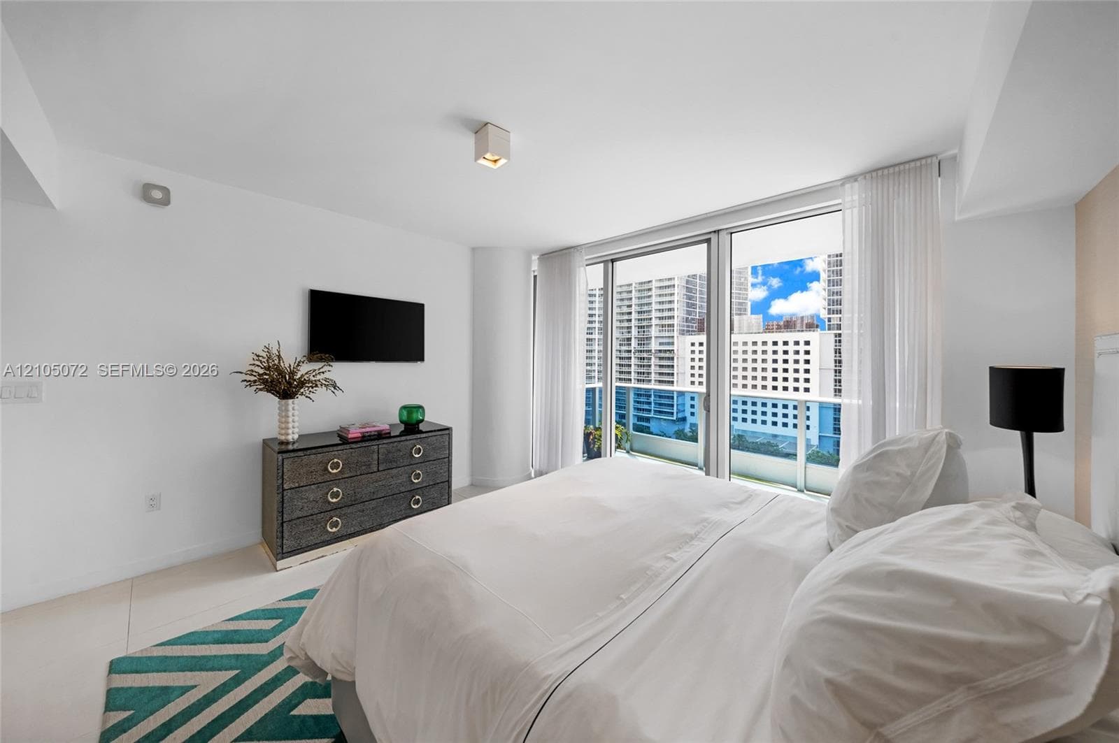 Primary bedroom with sliding glass doors connecting directly to the upper private terrace.