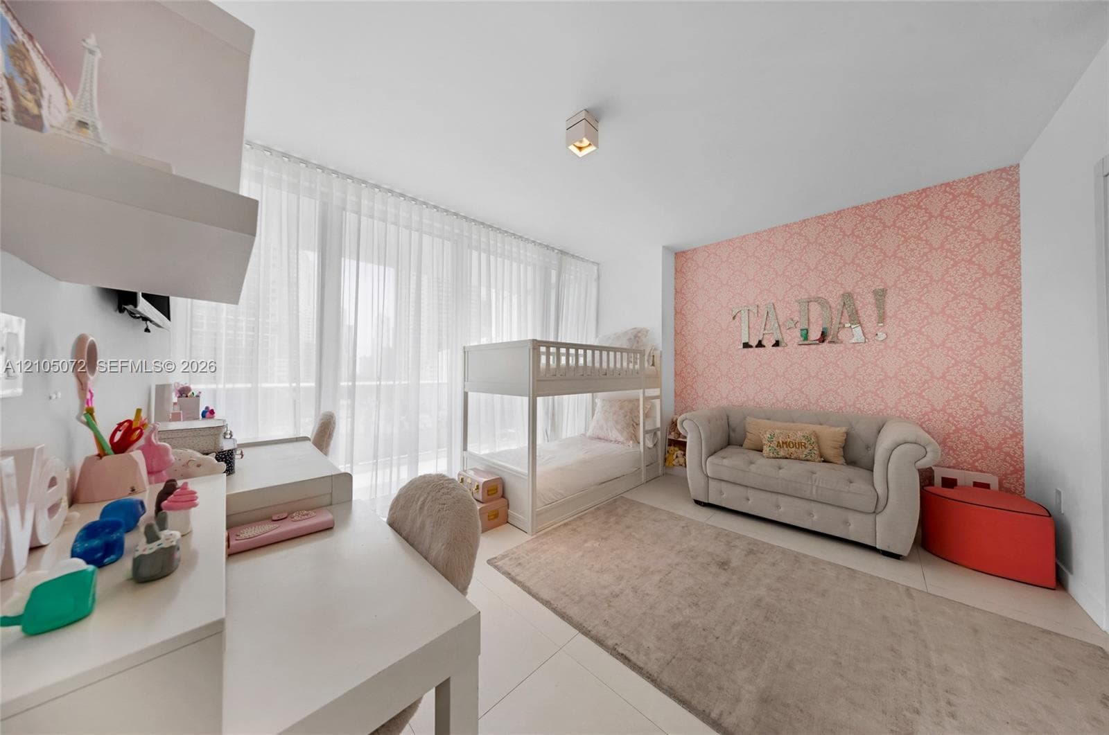 Secondary bedroom furnished with bunk bed, sofa, and a dedicated study area.