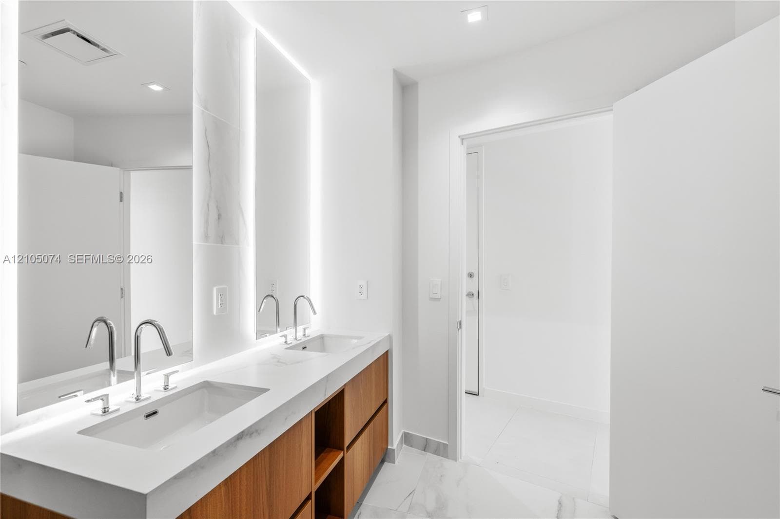 Spacious private balcony featuring large-format tile flooring, a curvilinear overhead architectural element, and a full-height glass railing