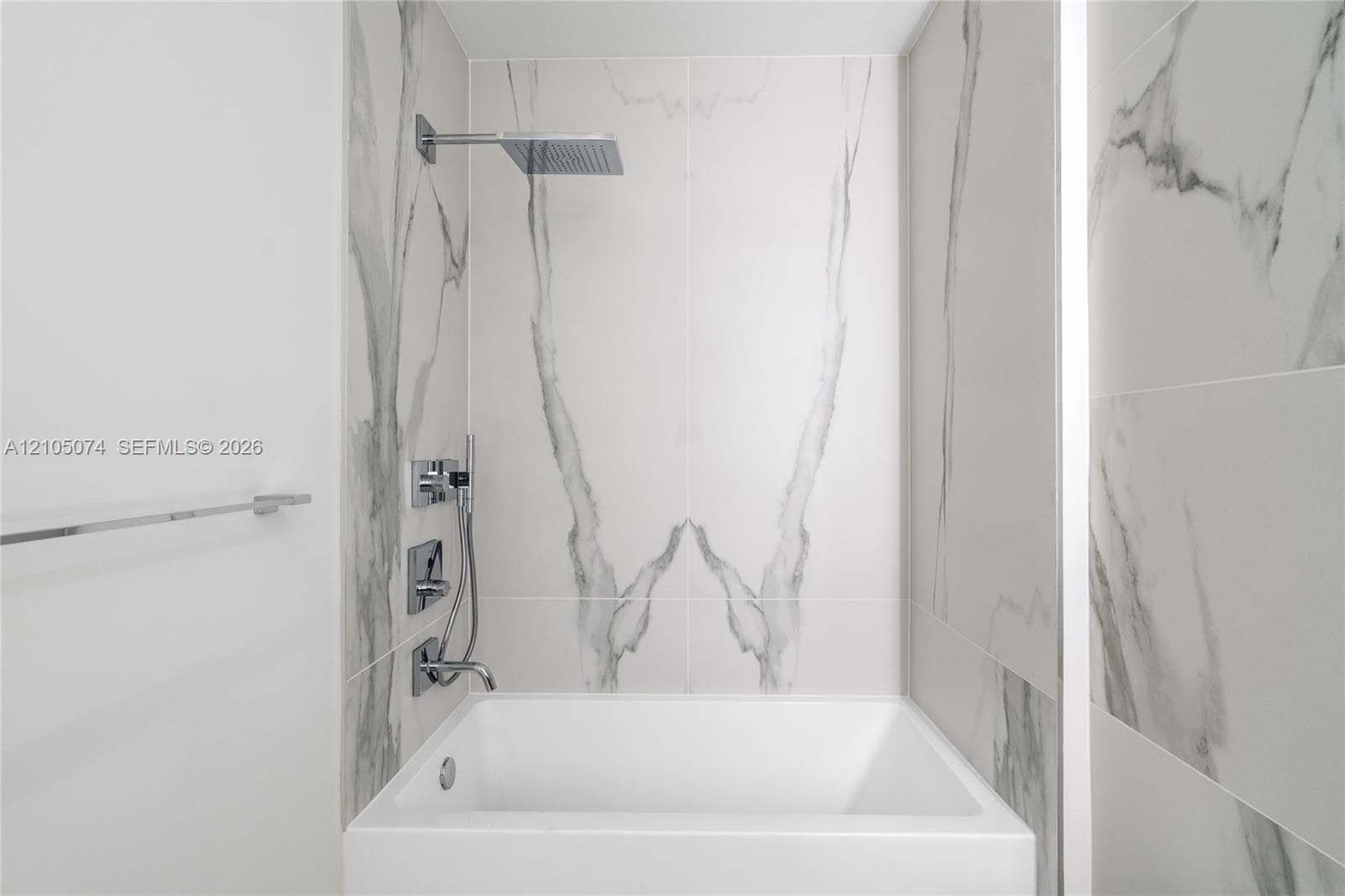 Neutral-toned interior space featuring light-colored tile flooring and minimalist, crisp white walls