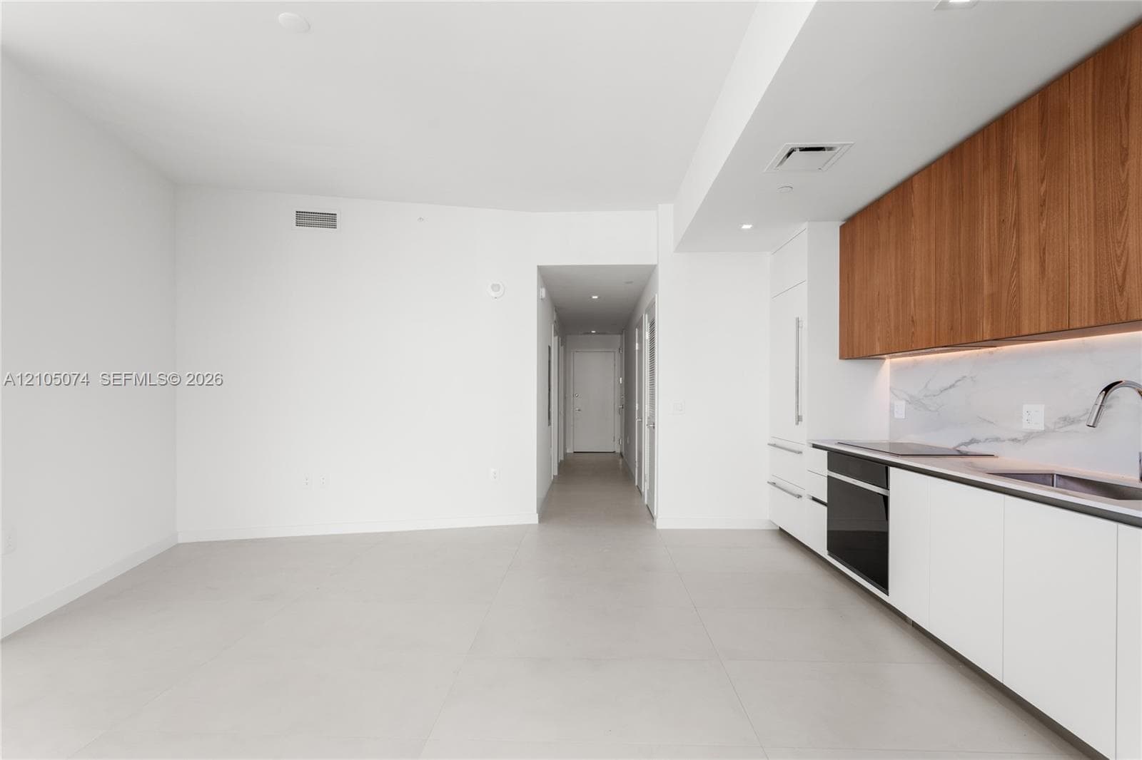 Curved wrap-around balcony featuring glass panel railings and light-colored tile flooring