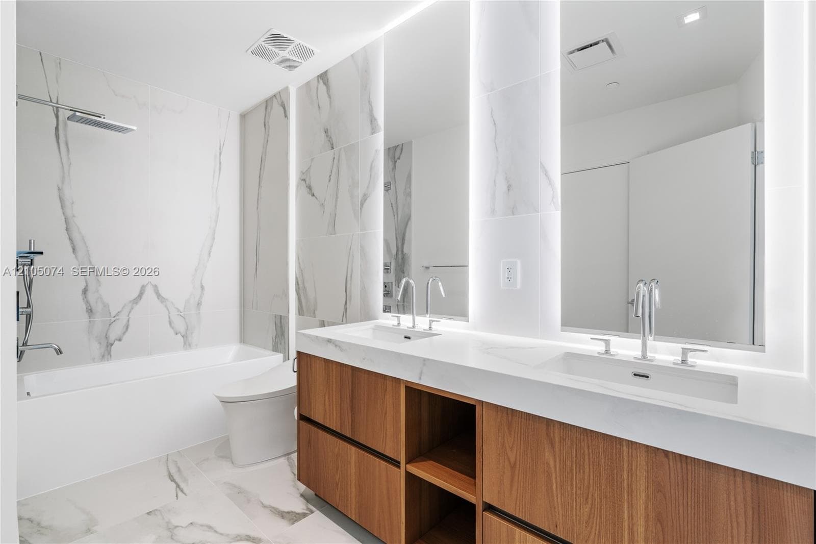 Neutral-toned large-format tile flooring, sliding closet doors, and solid-core swing door with brushed nickel hardware