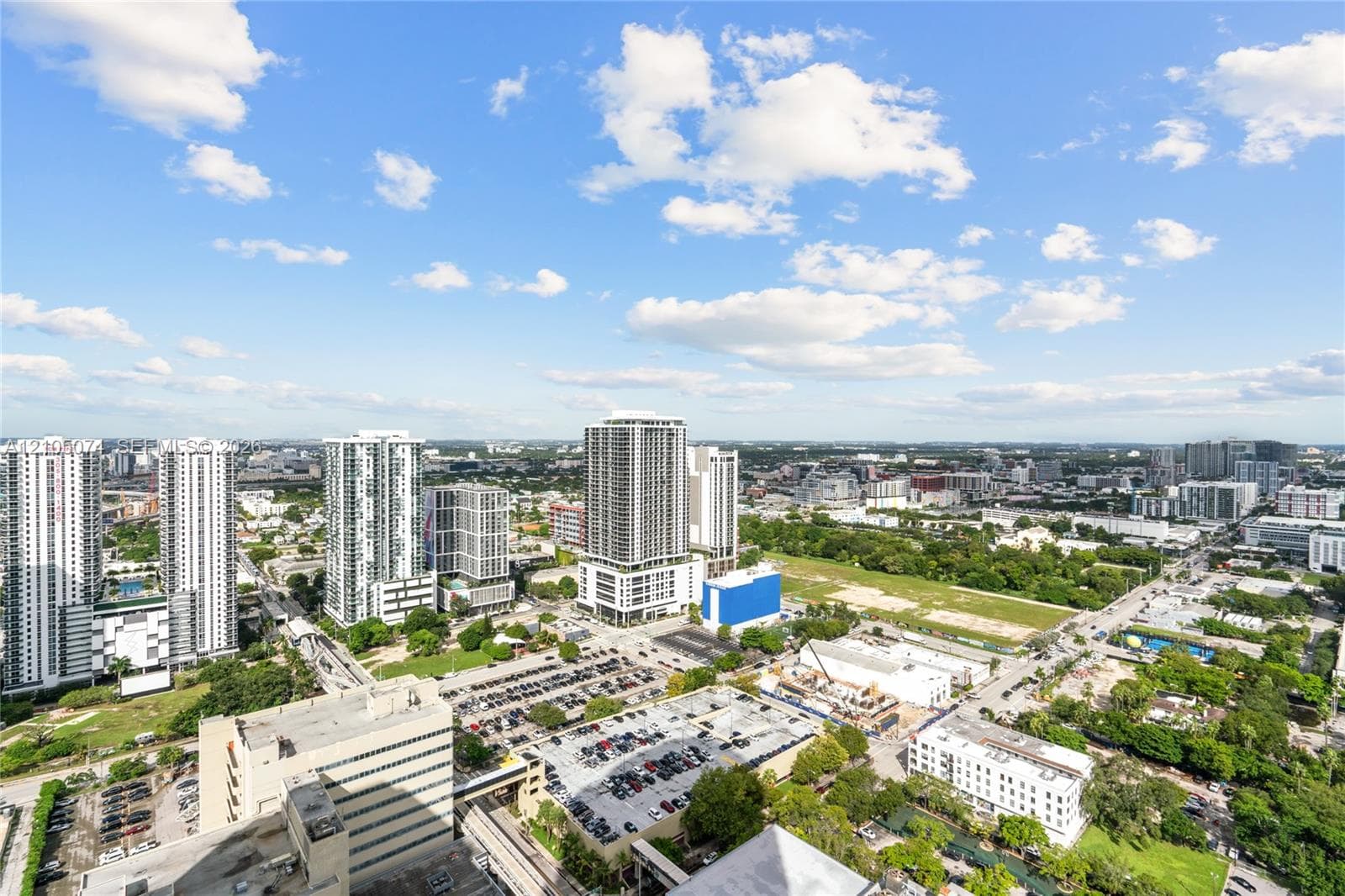 Expansive terrace featuring large-format tile flooring, full-height glass sliding doors, and a sleek glass-paneled railing