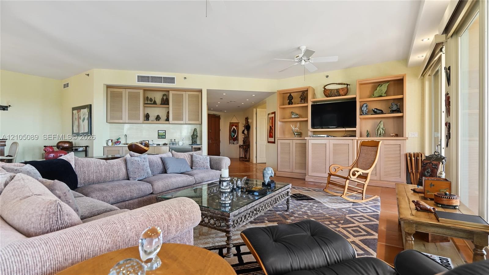 Living area featuring built-in cabinetry, recessed lighting, ceiling fan, and floor-to-ceiling glass sliding doors