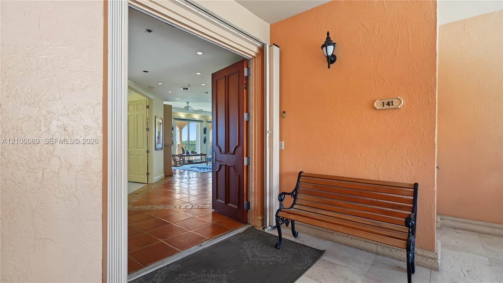 Entryway featuring a solid wood door with decorative paneling, recessed lighting, and tile flooring