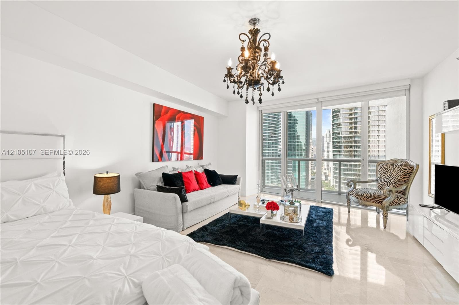 Polished tile flooring throughout, featuring a decorative chandelier and full-height glass doors