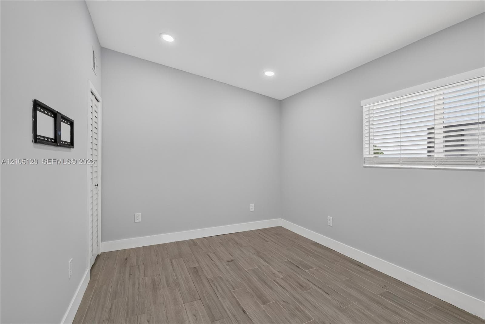 Neutral interior featuring wood-finish flooring, recessed lighting, and horizontal window blinds