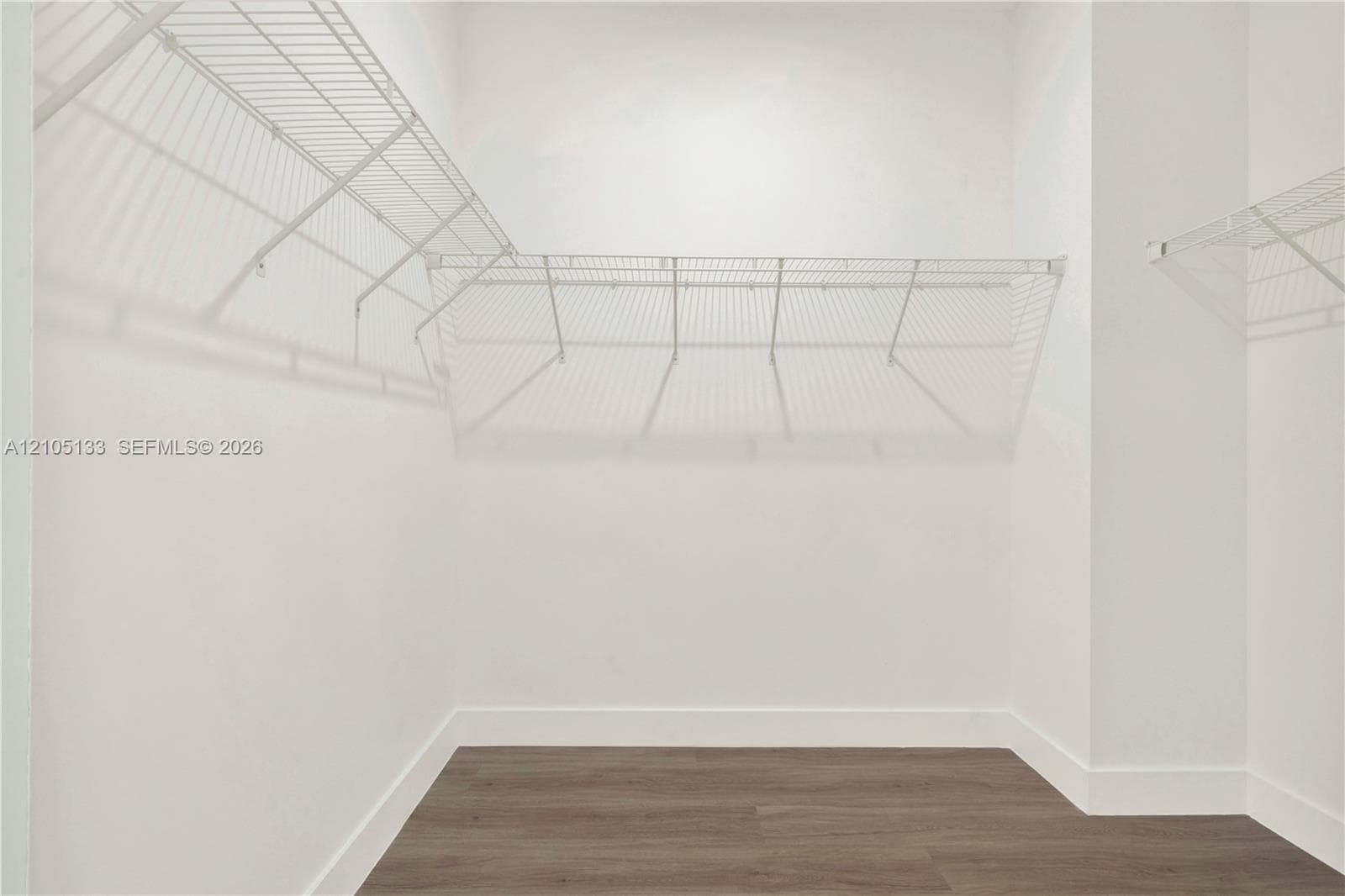 Wire shelving system, white walls, and wood-finish flooring