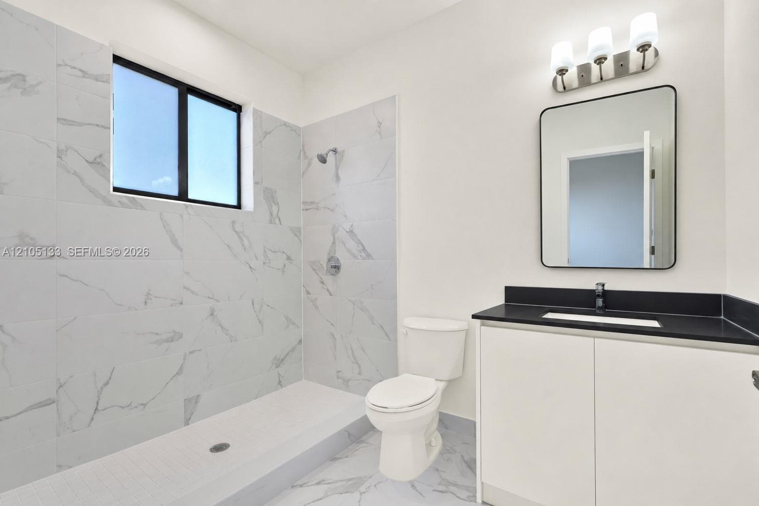 White vanity with black countertop, built-in rectangular sink, and matte black faucet