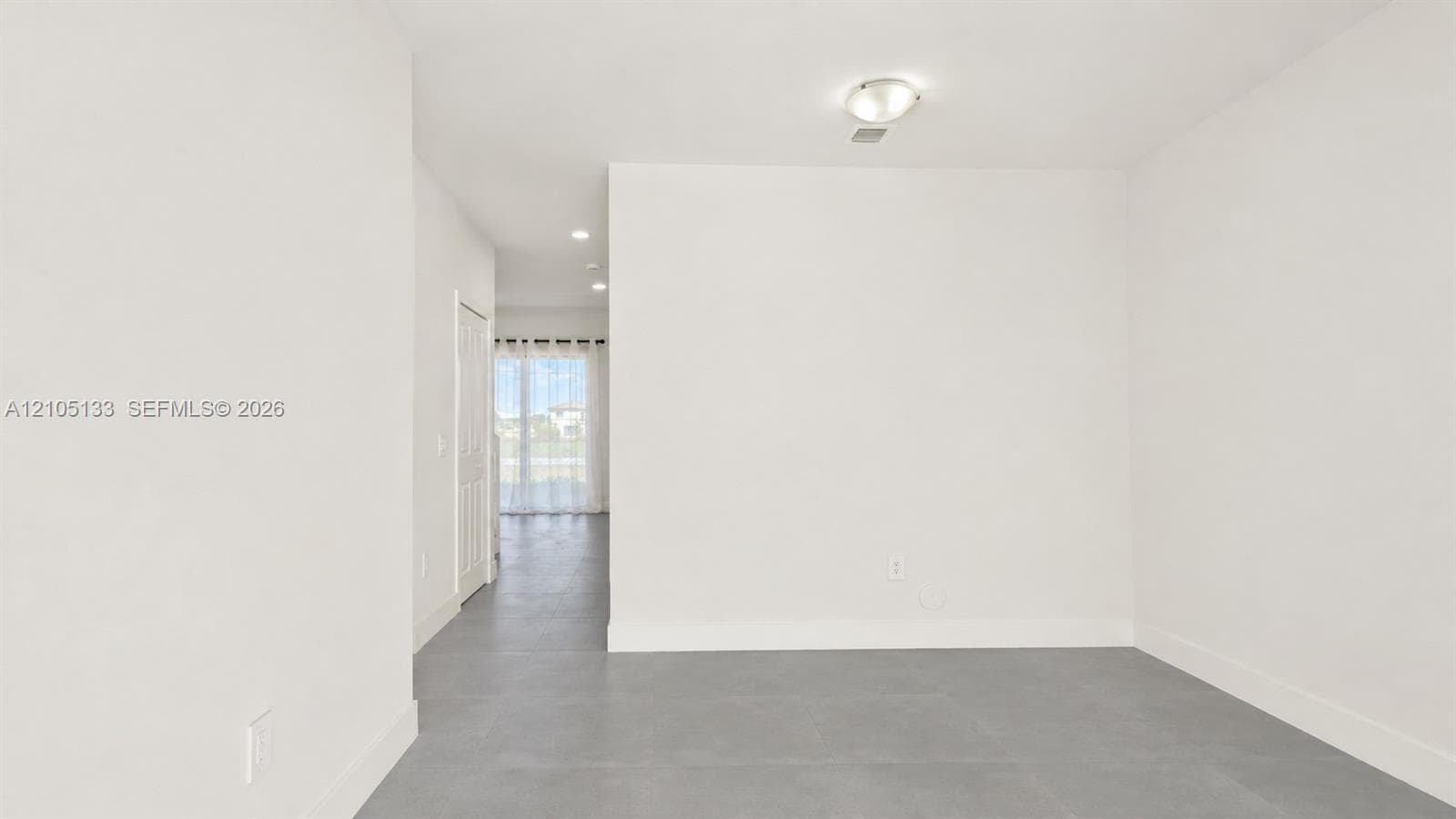 Recessed lighting, flush mount lighting, white walls, and gray flooring