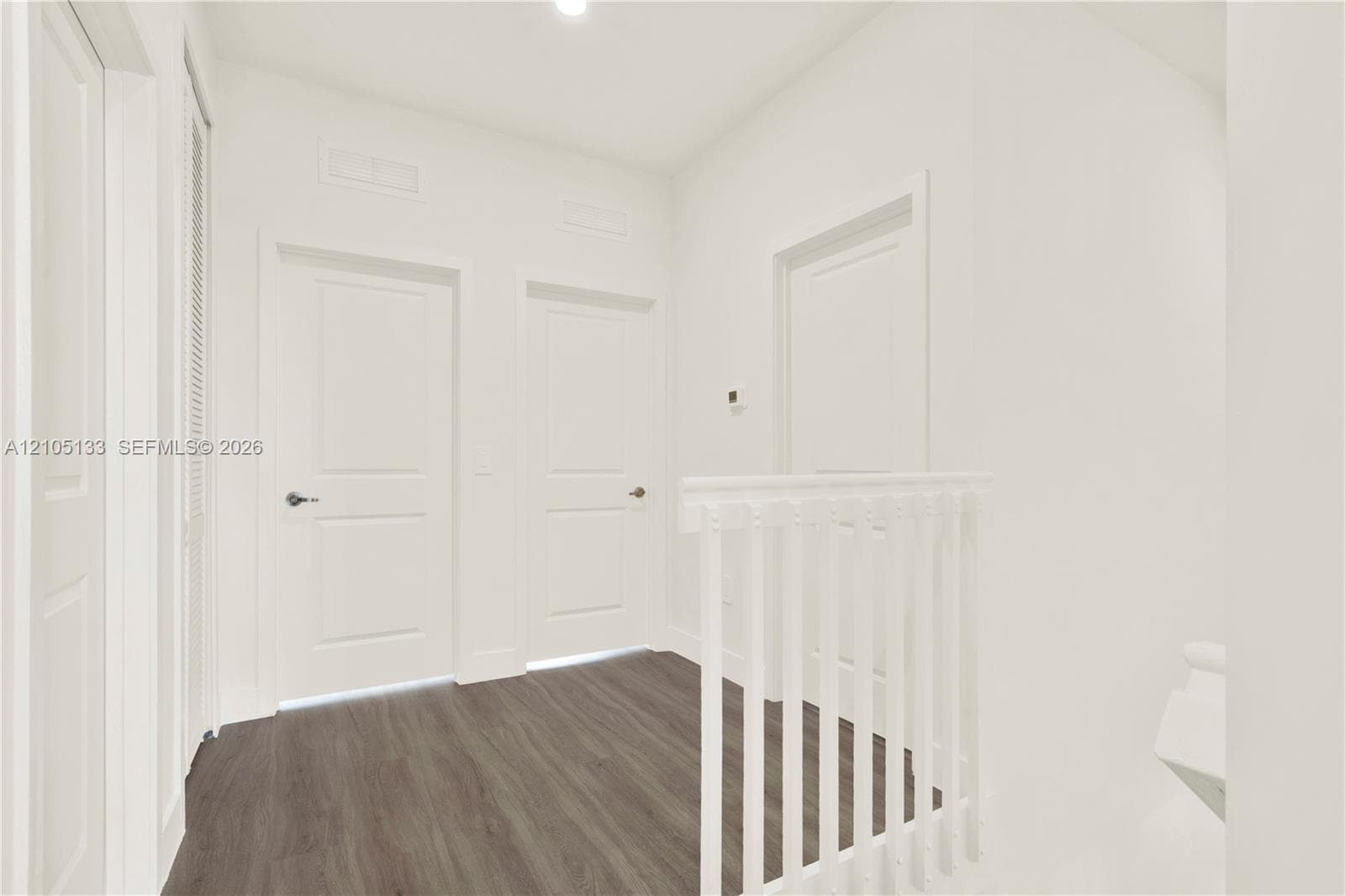 Wood-finish flooring with crisp white walls and white interior doors