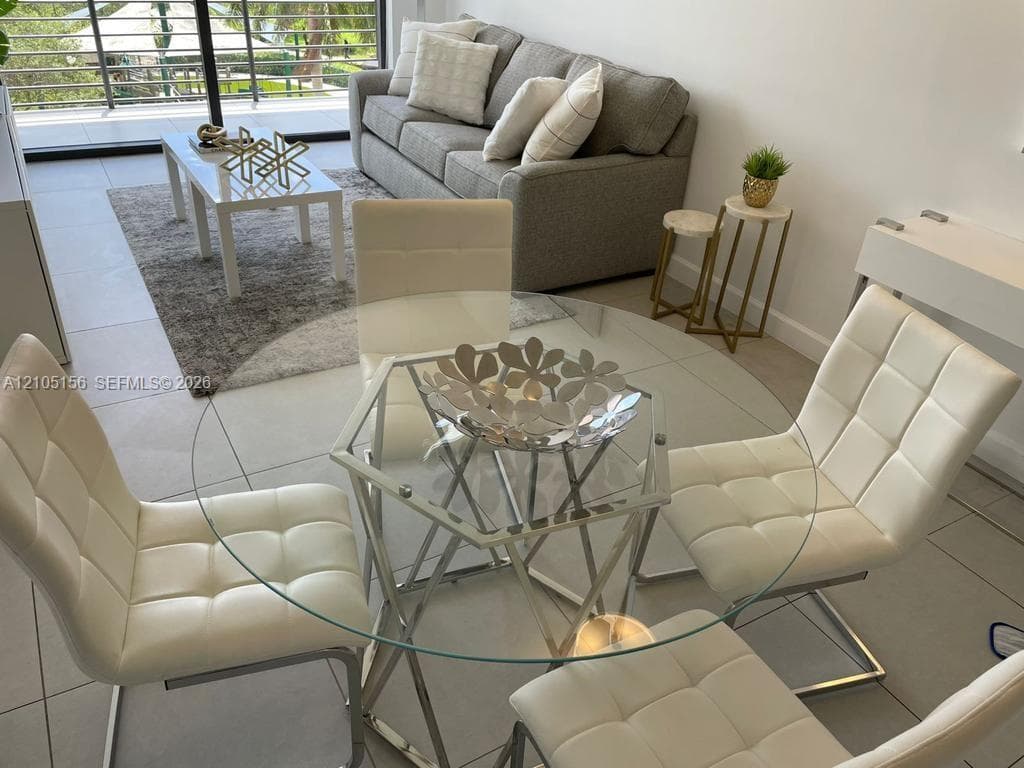 Large-format tile flooring, neutral wall palette, and sliding glass door with balcony access