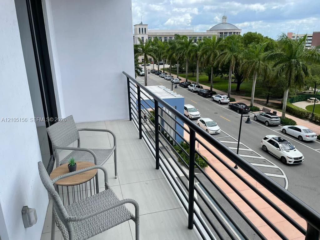Private balcony featuring large-format tile flooring and a black metal railing