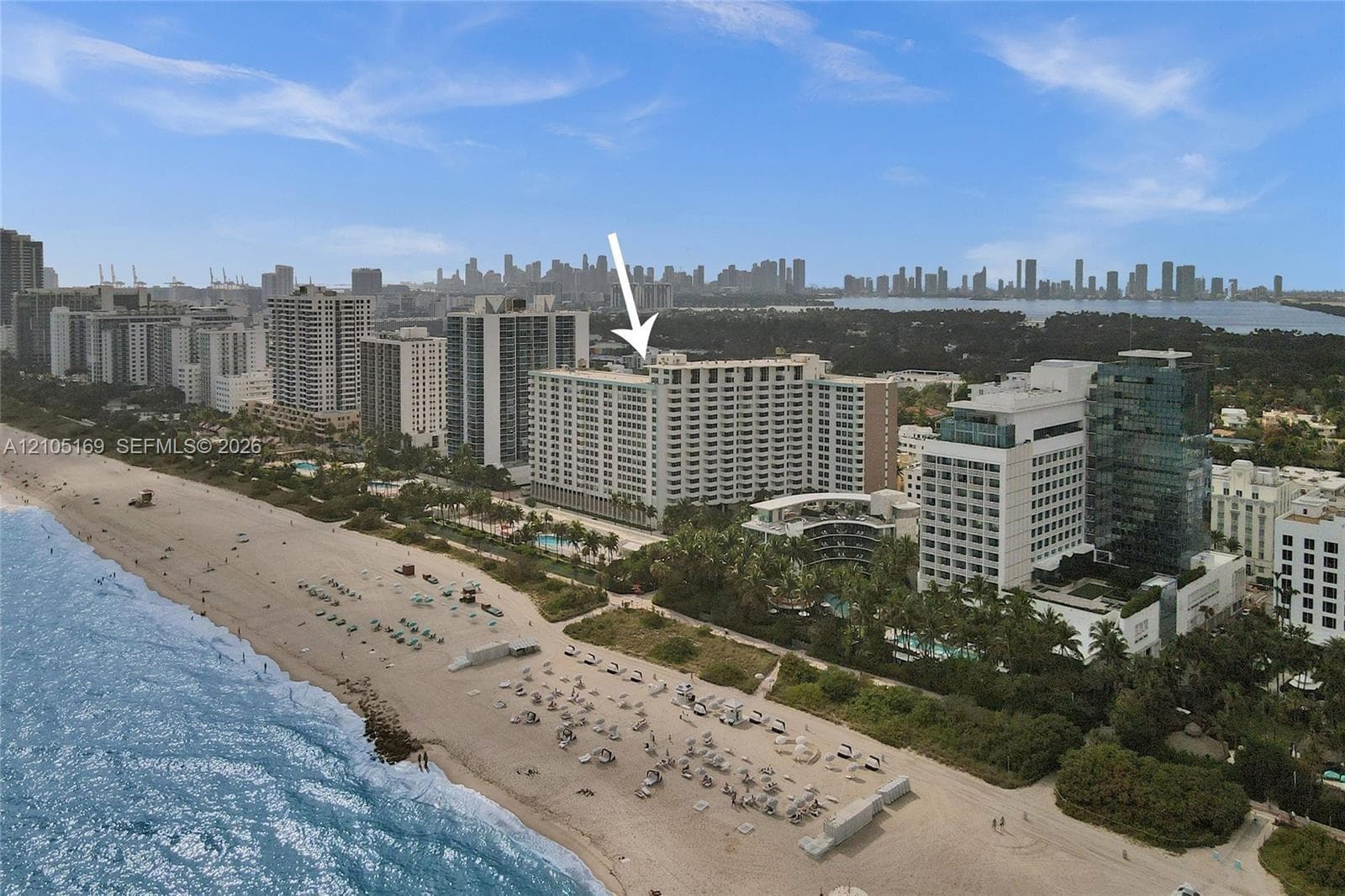 Aerial perspective showcasing a high-rise building with a cityscape background and adjacent beachfront