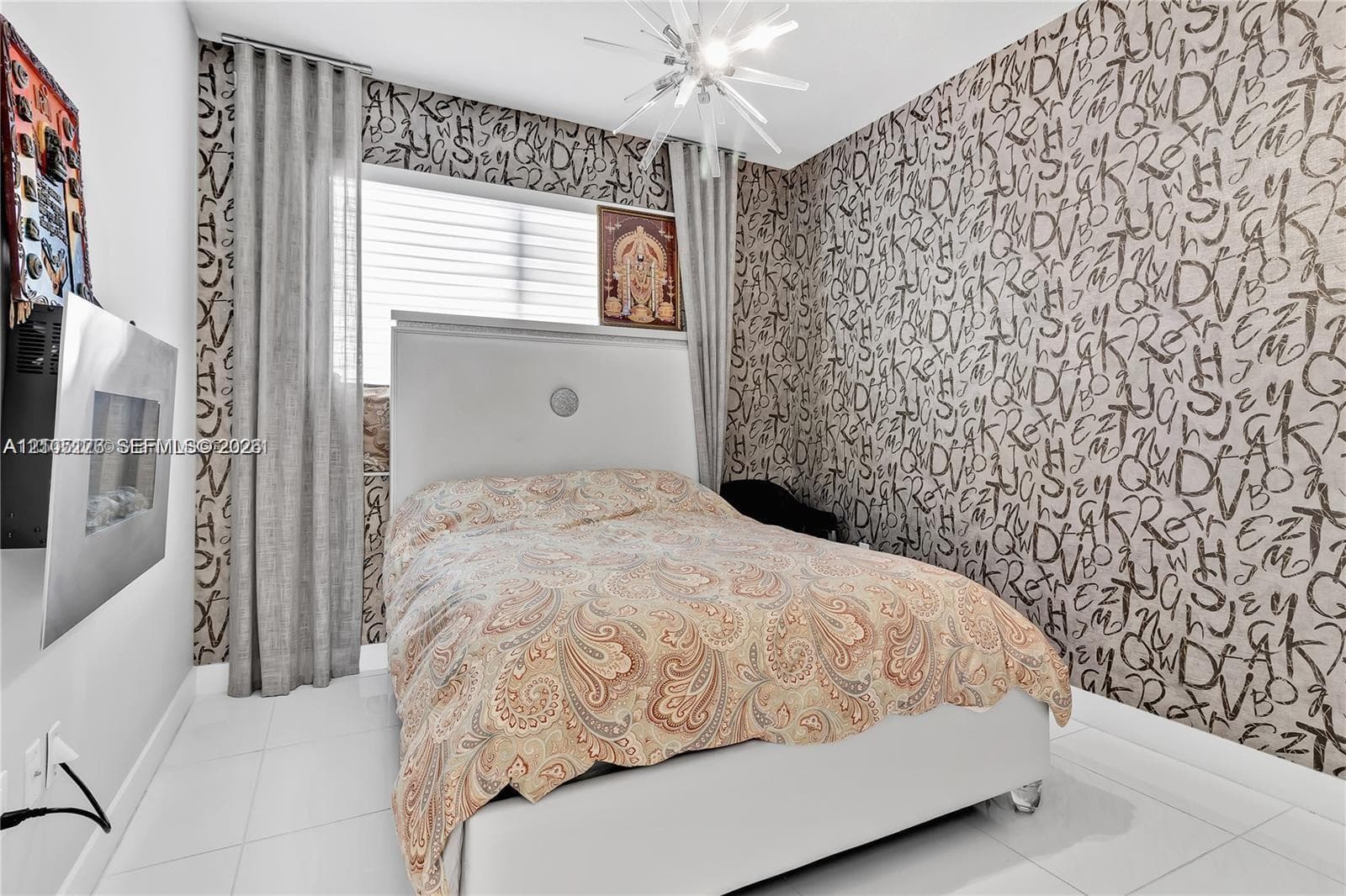 Room featuring large-format tile flooring, a wall-mounted electric fireplace, floor-to-ceiling drapery, and a contemporary multi-arm chandelier