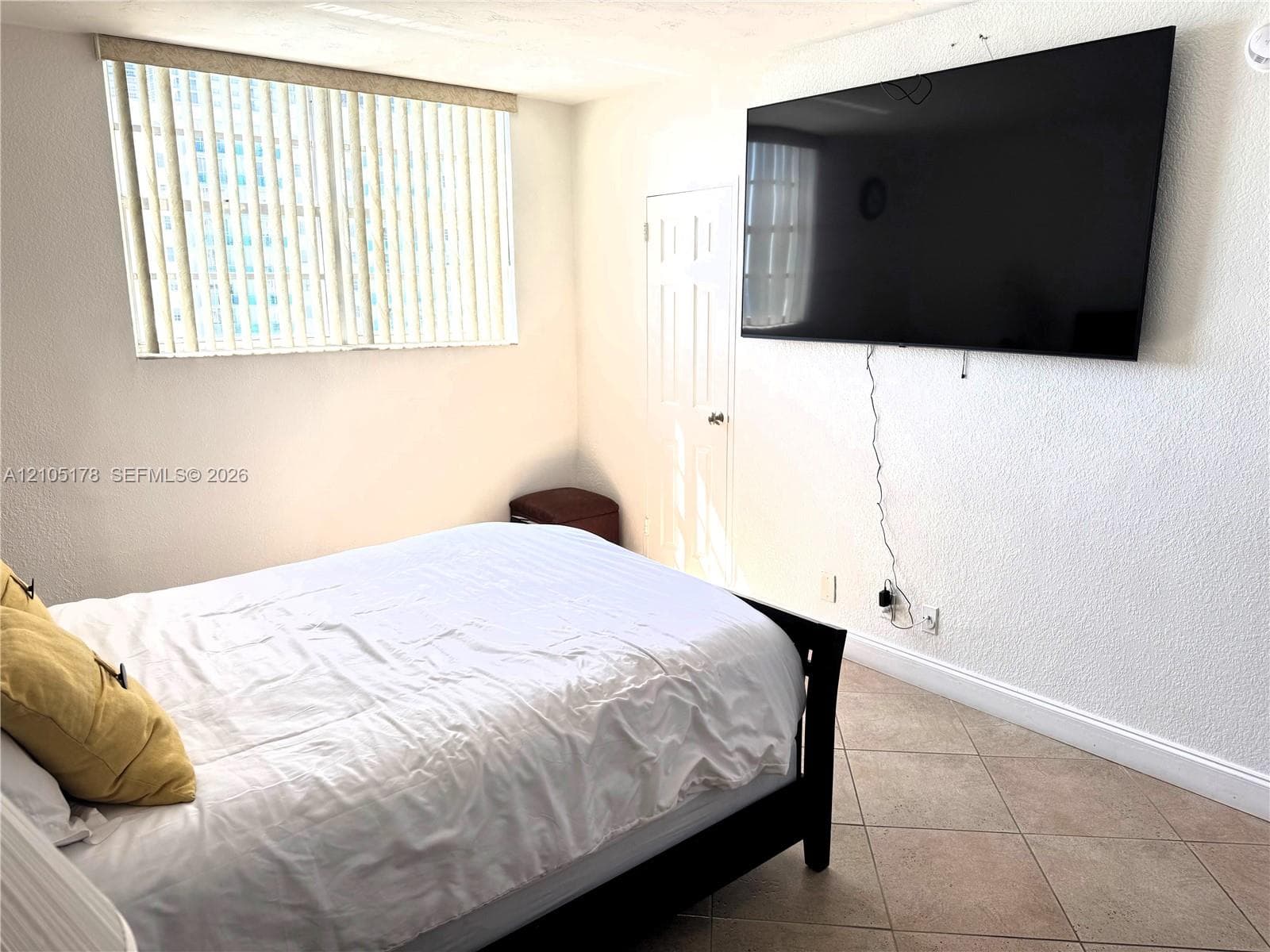 primary bedroom with 75" tv