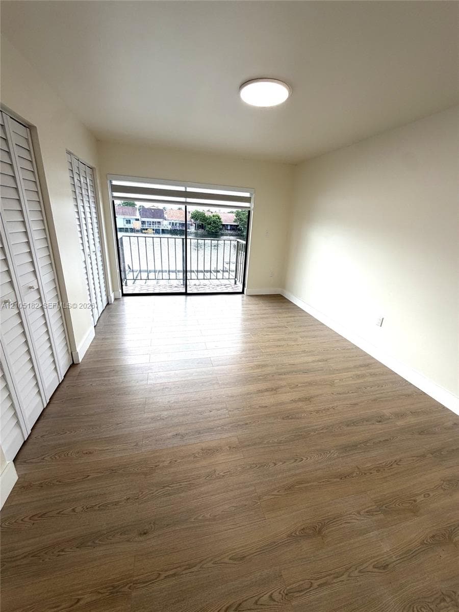 Wood-finish flooring, white walls, and a recessed ceiling light