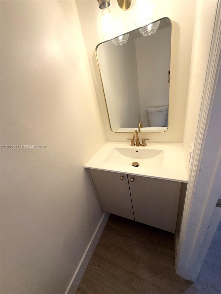 Modern vanity with integrated sink, gold-finish faucet, and coordinating gold-frame mirror