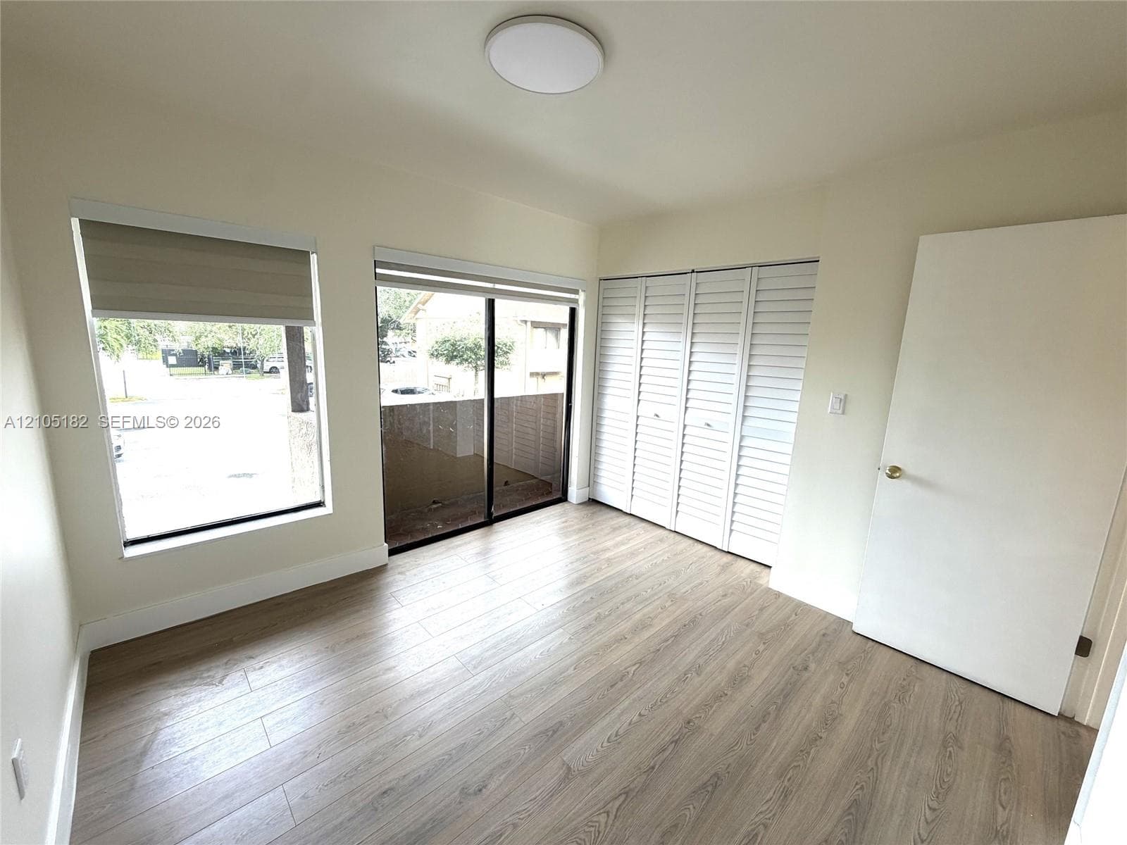 Wood-finish flooring, white walls, and a contemporary ceiling light fixture