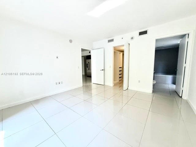 Large-format ceramic tile flooring, built-in closet shelving, and solid-core interior doors
