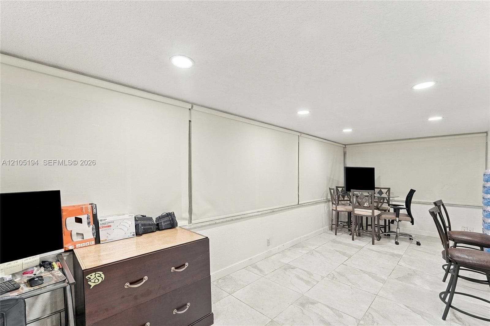 Large-format tile flooring, recessed ceiling lighting, and expansive windows with custom roller shades