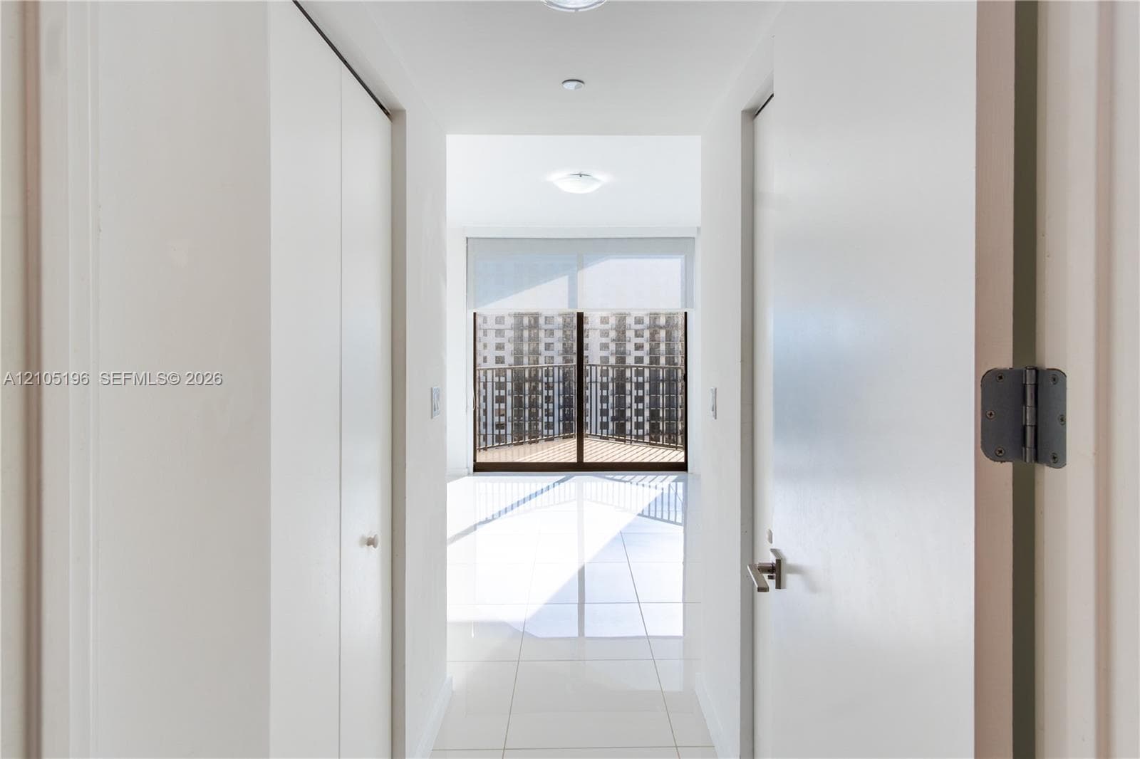 White tile flooring, recessed lighting, and a private balcony with protective railing