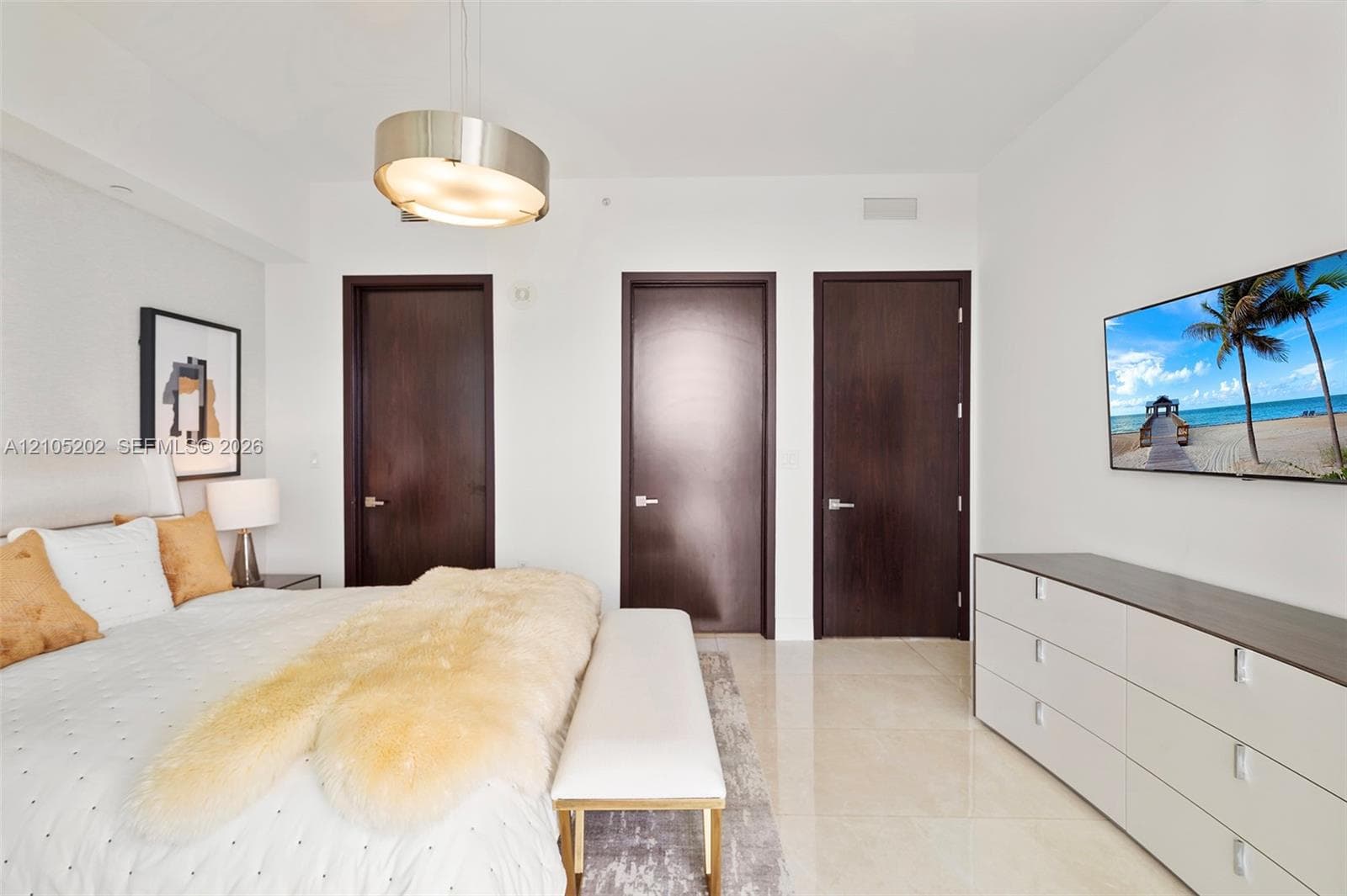 Large-format stone tile flooring, drum-style pendant lighting, and solid-core dark wood doors