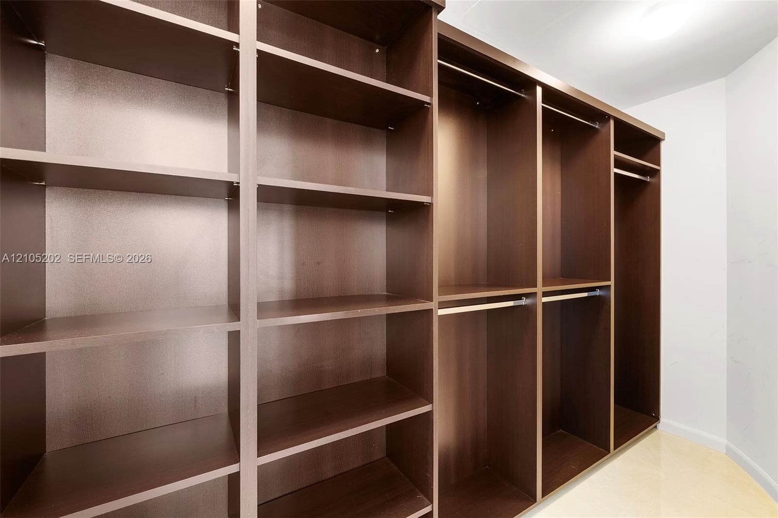Custom dark-finish wood cabinetry featuring tiered shelving and integrated hanging rods