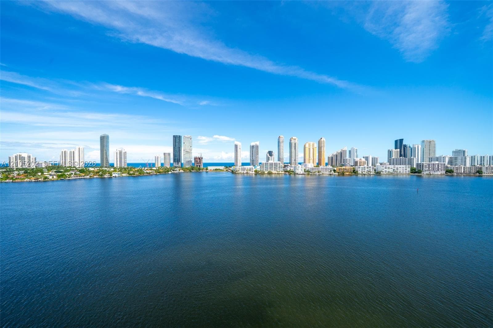 Expansive waterfront setting featuring a wide canal and a distant coastal cityscape skyline