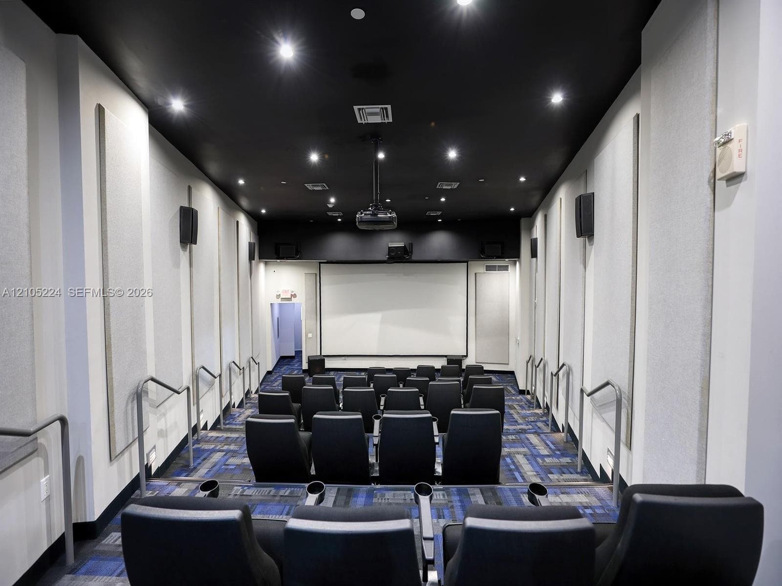 Theater room featuring a large projection screen, recessed lighting, and a dark ceiling