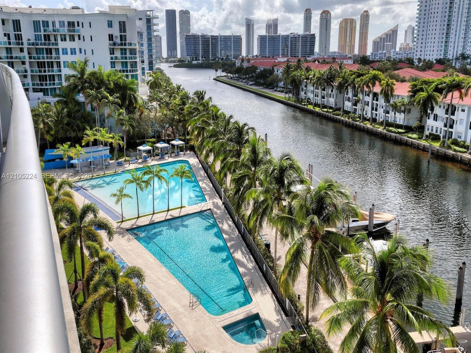 Expansive outdoor area featuring two swimming pools, a hot tub, and lush palm trees