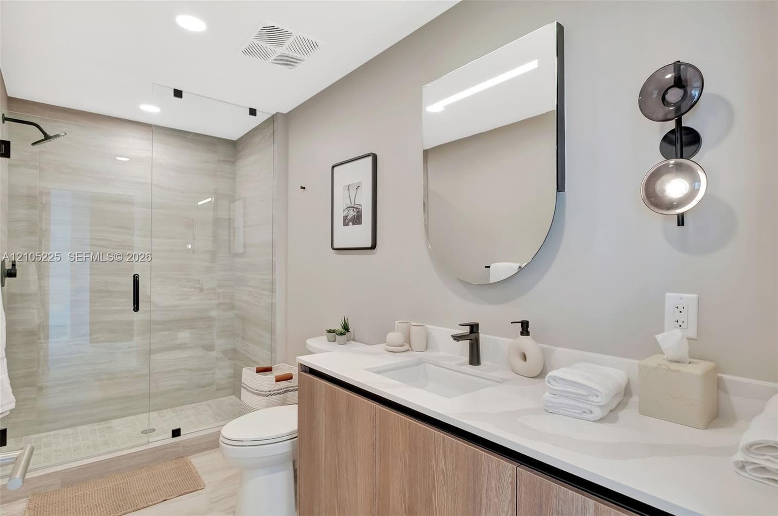 Glass-enclosed shower with large format tile surround