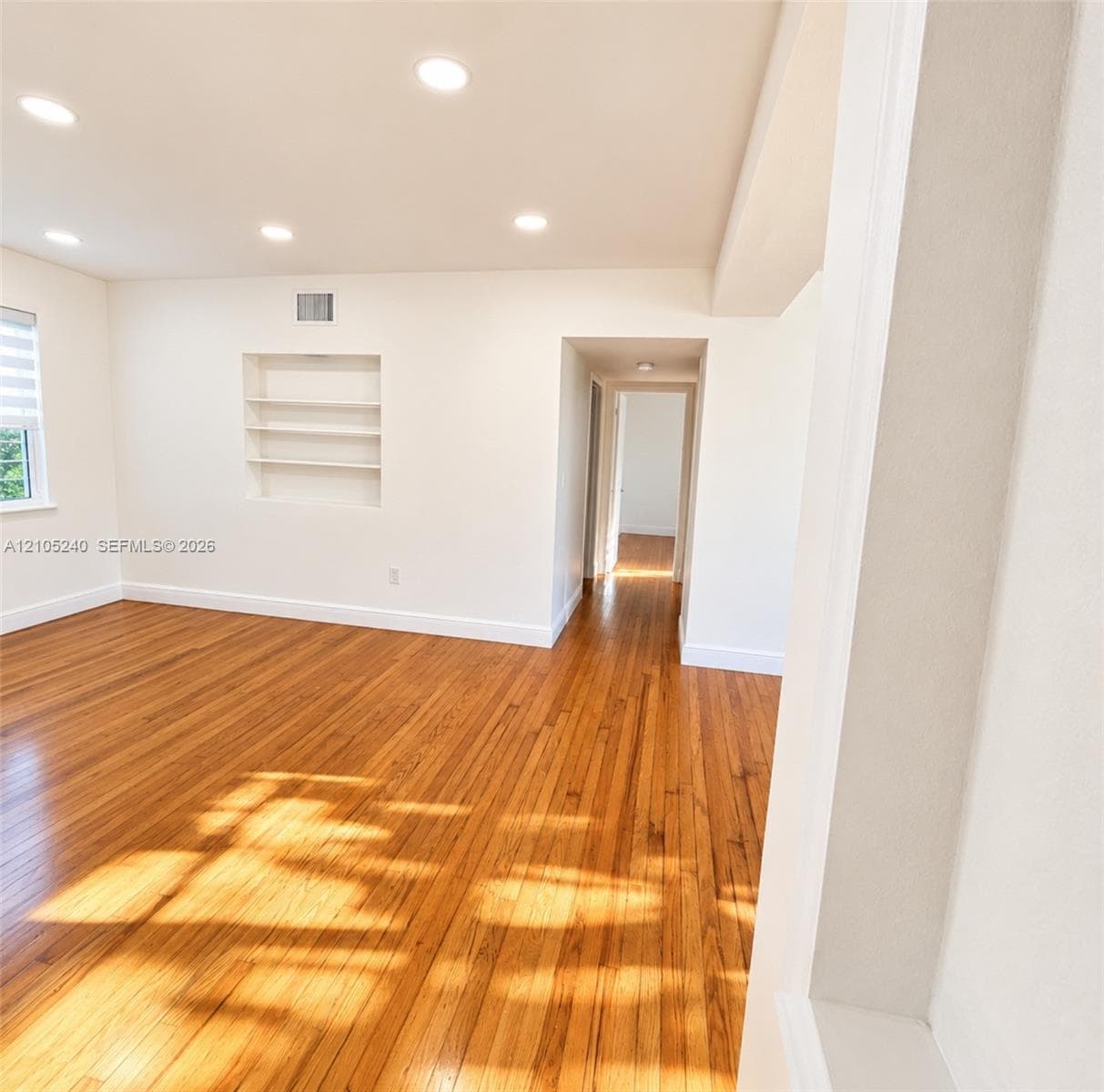 Wood-finish flooring, recessed lighting, and built-in wall shelving