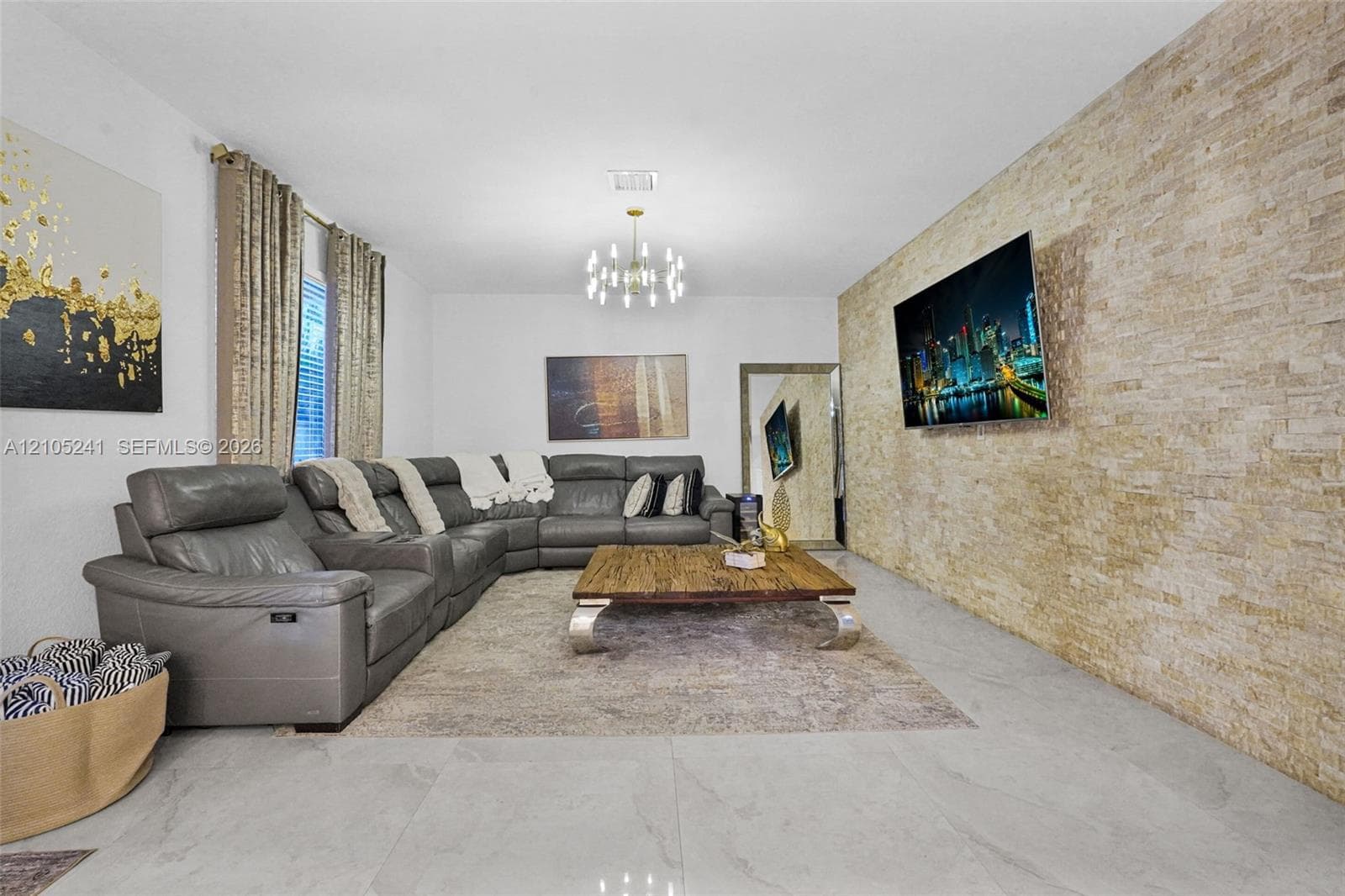 Light-toned stone accent wall, large format tile flooring, and recessed lighting