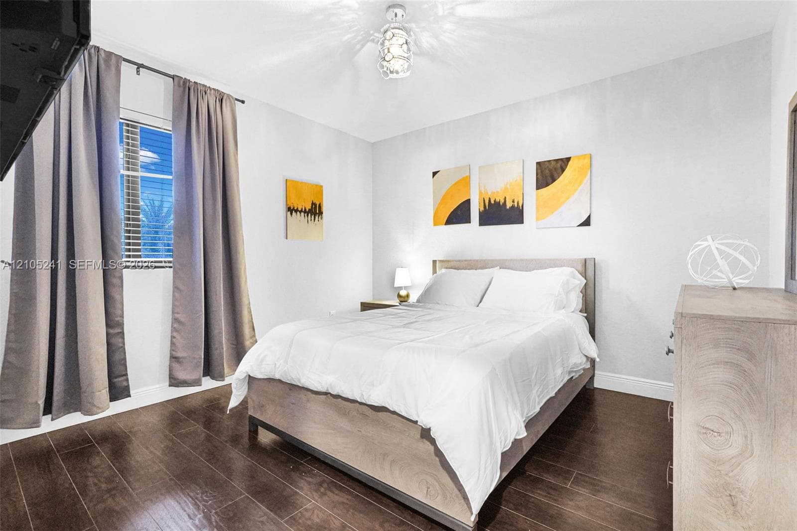 Hardwood-finish flooring, recessed window with blinds, ceiling-mounted light fixture, and light-toned walls