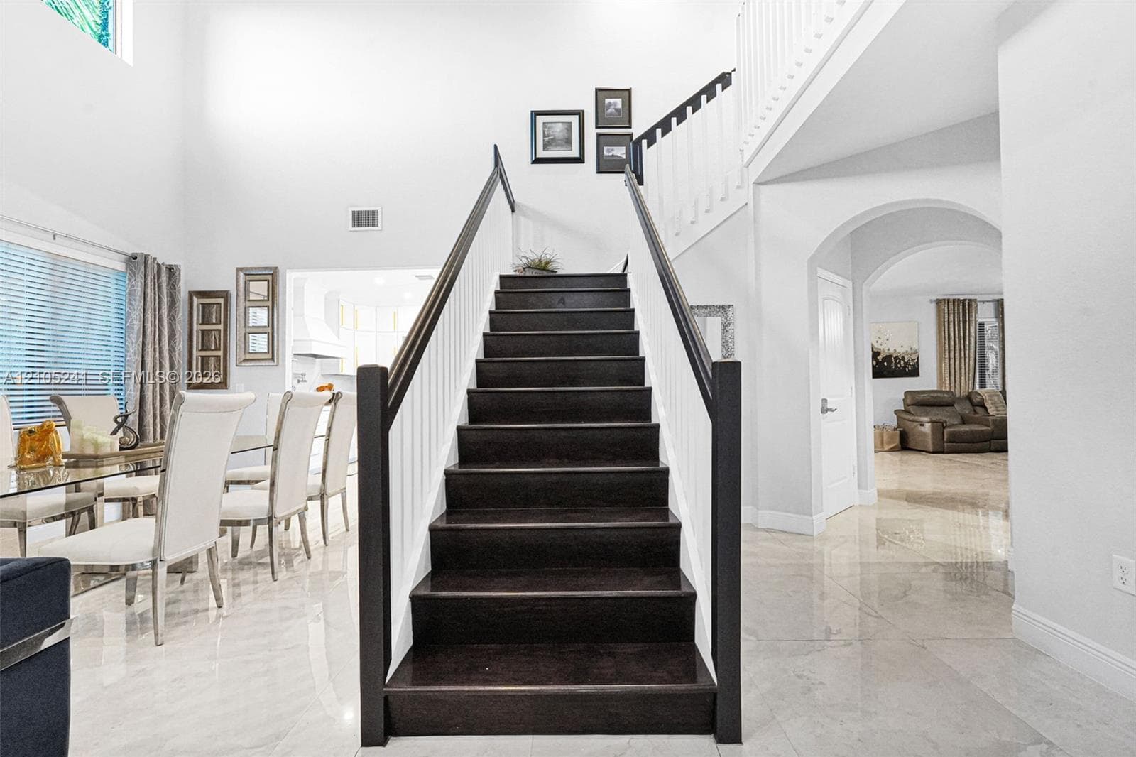 Dark wood-finish staircase with white balusters, leading to an upper level