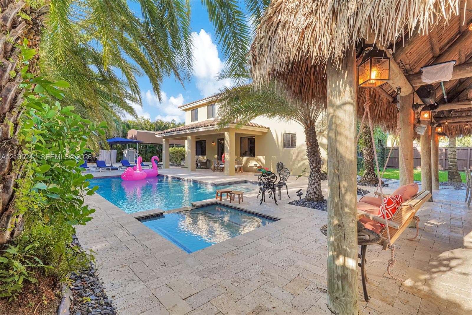 Expansive paver patio with an in-ground pool and spa