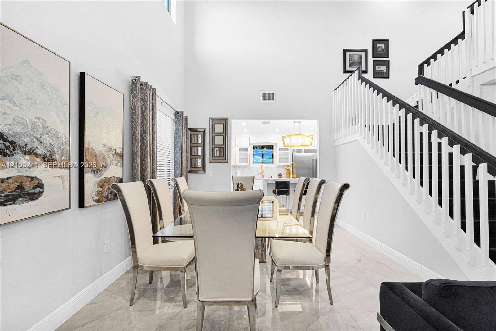 High ceilings, staircase with dark wood-finish handrail, tile flooring, window with blinds, and recessed lighting