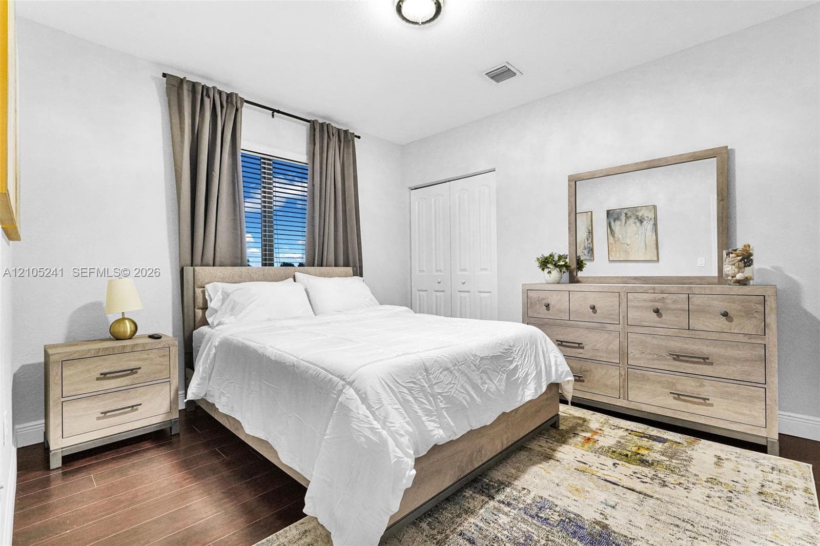 Wood-finish flooring, window with blinds, bi-fold closet doors, and recessed lighting