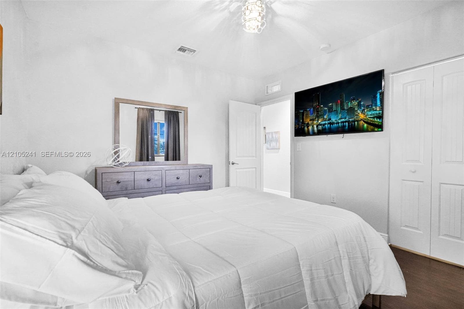 White walls, wood-finish flooring, and white bi-fold closet doors