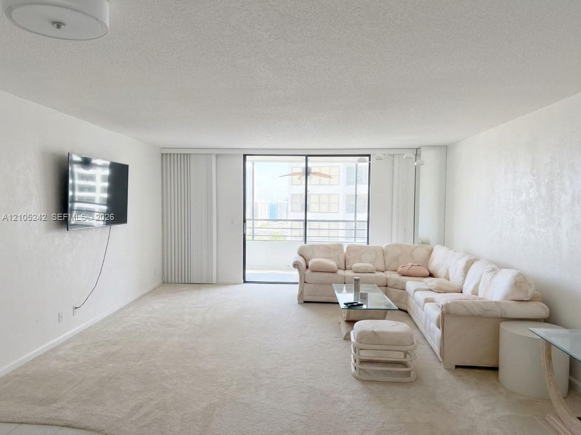 Recessed lighting in ceiling, neutral wall finish, wall-to-wall carpeting, floor-to-ceiling glass doors, and a private balcony
