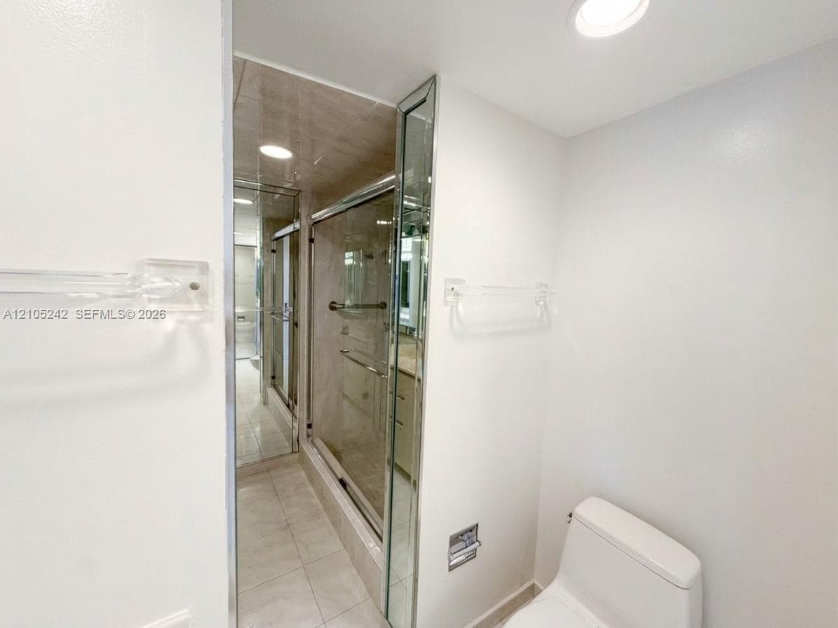 Bathroom featuring a commode, recessed lighting, and a glass-enclosed shower